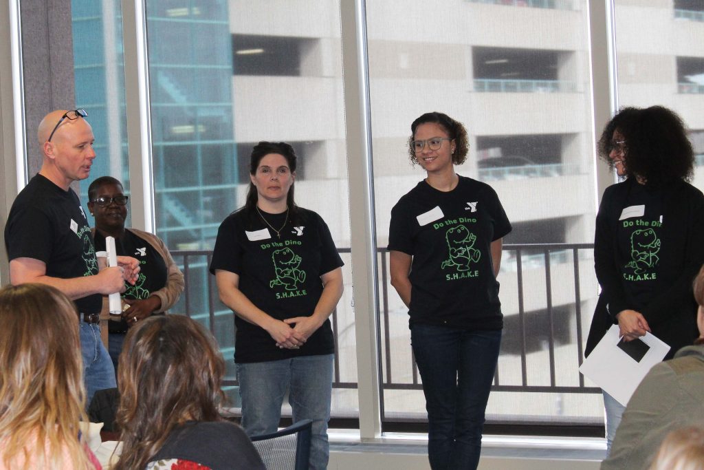 A group of 4 people who implement the Pyramid model at the Waterbury Y wearing Do the Dino shirts.